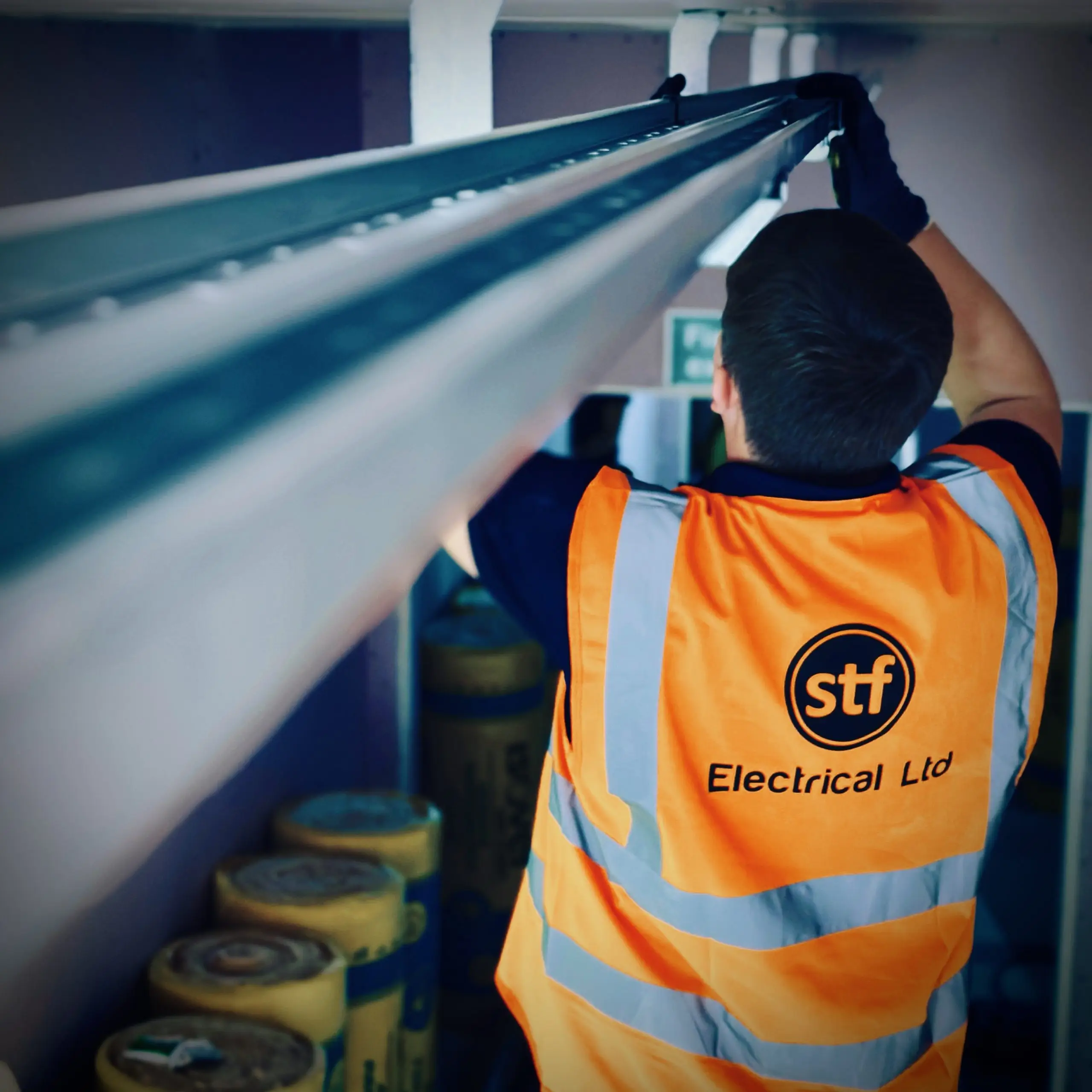 An STF Electrical Ltd electrician expertly installs cable tray in a commercial property in Liverpool.